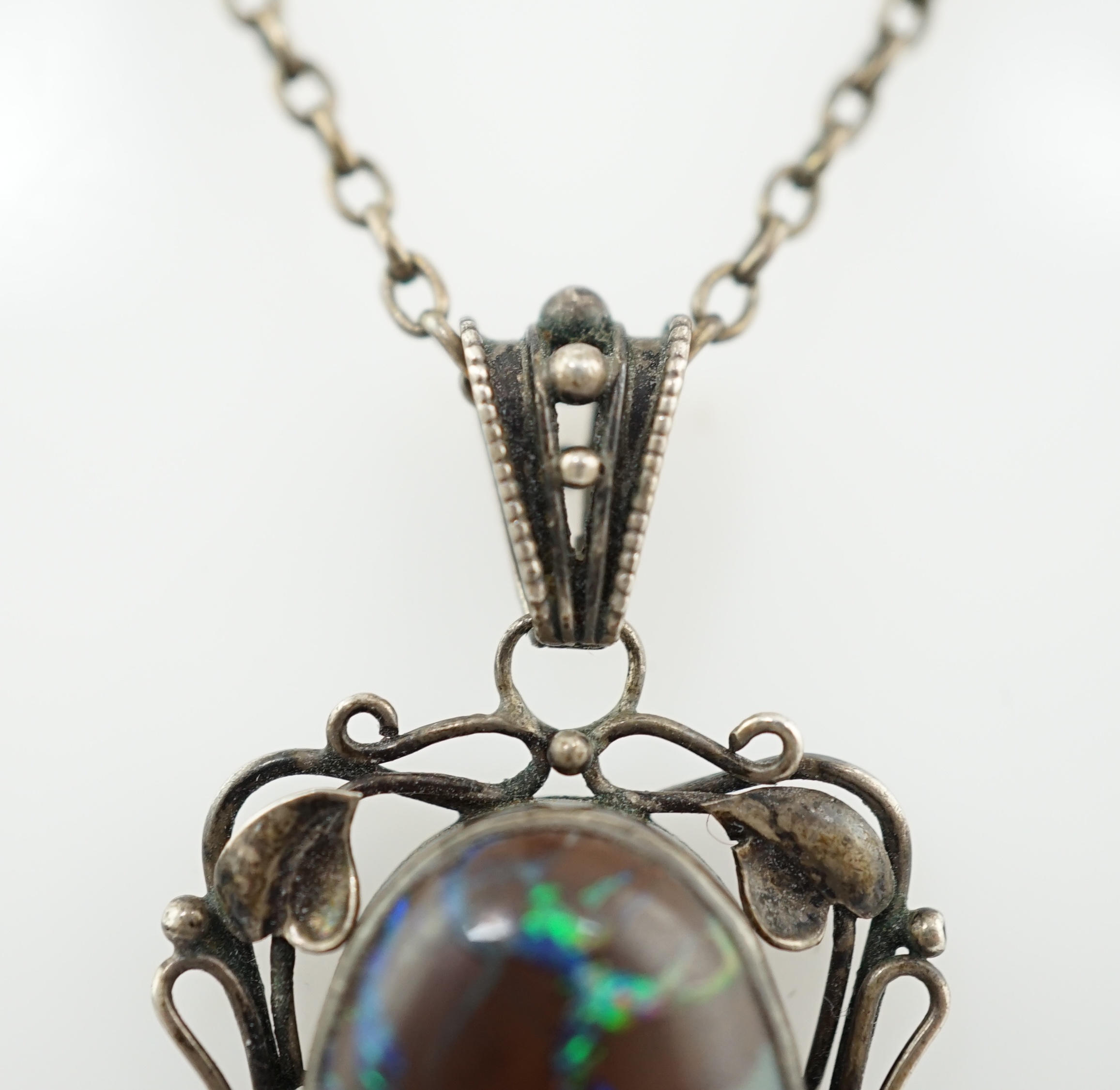 An Art Nouveau silver and oval black opal set drop pendant necklace